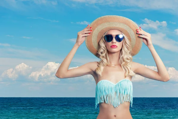 Attractive young woman in bikini and hat on a background of sea beach. — Stock Photo, Image