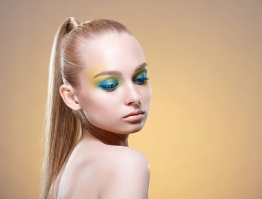 Parlak makyaj ve uzun sarı saçlı güzel kadın.