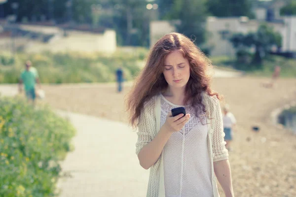 市街地環境における携帯電話を持つ若い女性. — ストック写真