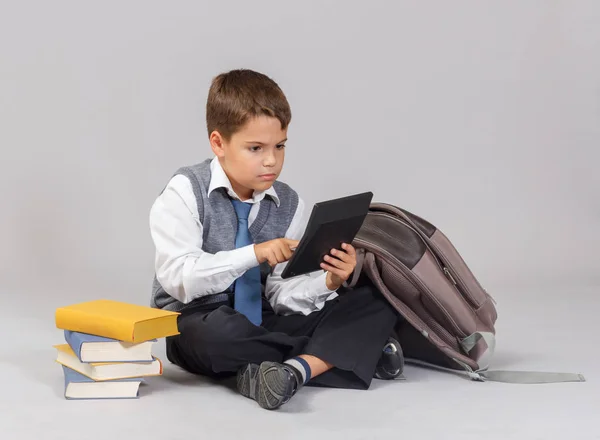 Jovem menino em idade escolar sentado com uma calculadora — Fotografia de Stock