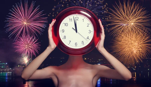 花火の背景に を示す大きな赤い時計を持つ女性 新しい年のお祝いのコンセプト — ストック写真