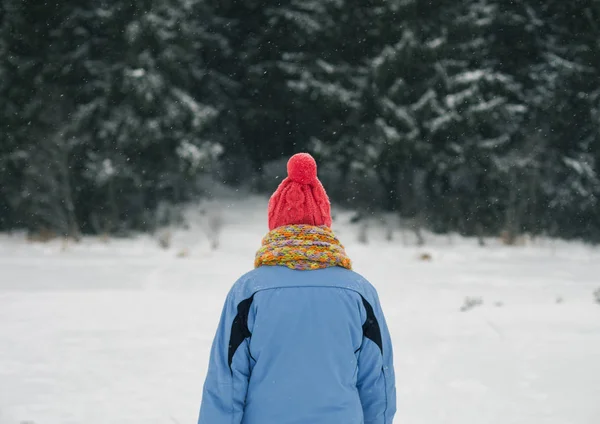 暗い冬の森の前に女性が立っている — ストック写真