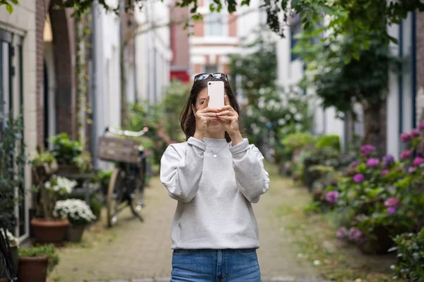 여자가 휴대폰으로 사진을 도시의 거리에서 — 스톡 사진