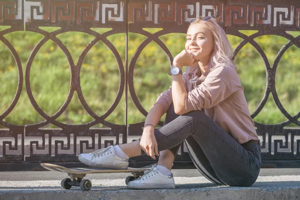 Uma Jovem Feliz Com Skate Descansa Enquanto Está Sentada Ambiente — Fotografia de Stock