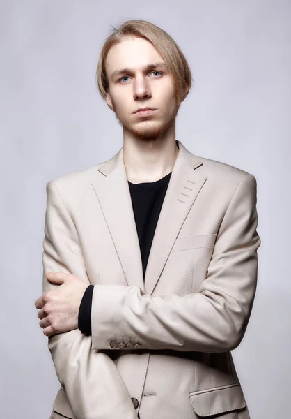 Young blond male model in beige man suit