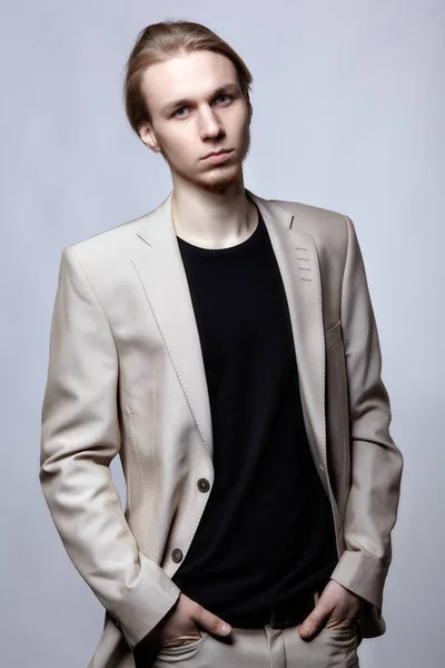 Young blond male model in beige man suit