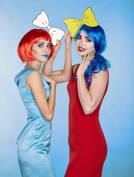 Females in red and blue wigs on blue background. Girls with yell