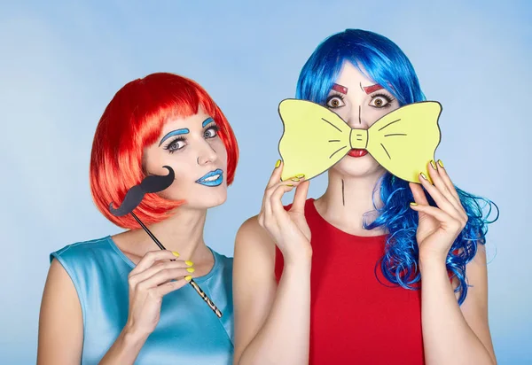 Females in red and blue wigs on blue background. Girls with yell