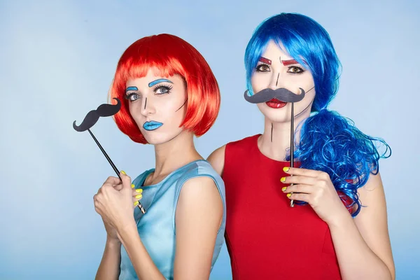 Females in red and blue wigs on blue background. Girls with fal