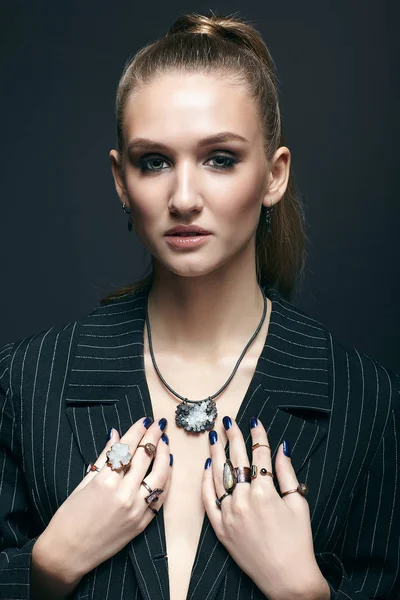 Young woman with many bijouterie rings with stones on fingers
