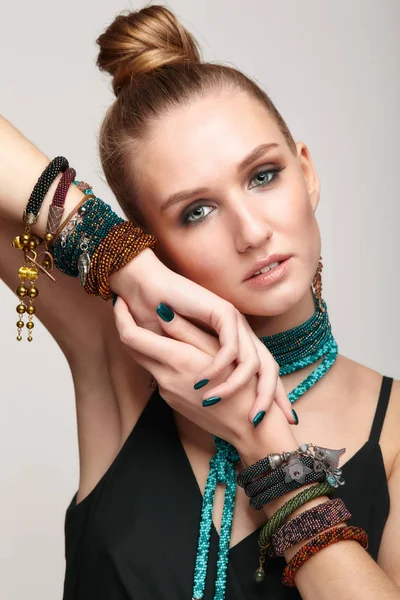 Beautiful woman in collar necklace and multiple bracelets.