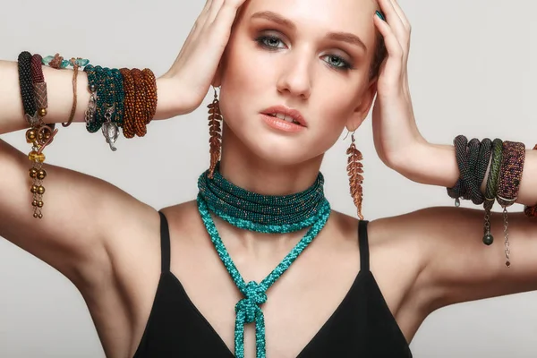 Beautiful woman in collar necklace and multiple bracelets.