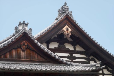 The curved roofs of Kuri, the temple kitchen, decorated with Morikuni (Onigawara  and kiri (family crest)) and gegyo (gable pendant). Kinkaku-ji temple. Kyoto. Japan