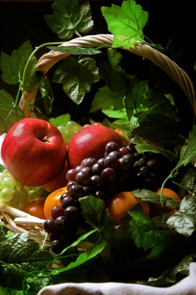 Cesta de frutas e folhas verdes — Fotografia de Stock