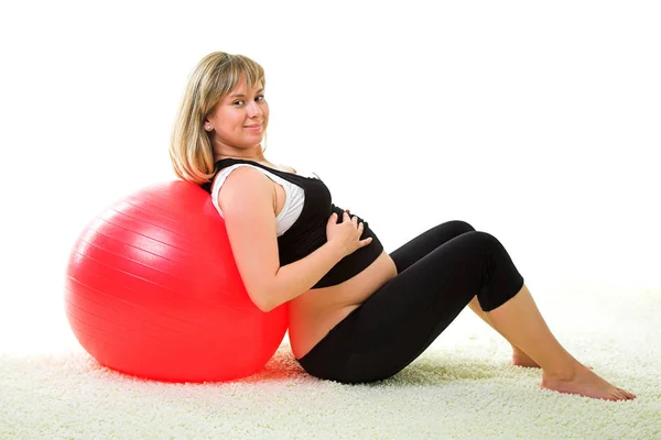 Беременная женщина делает упражнения — стоковое фото