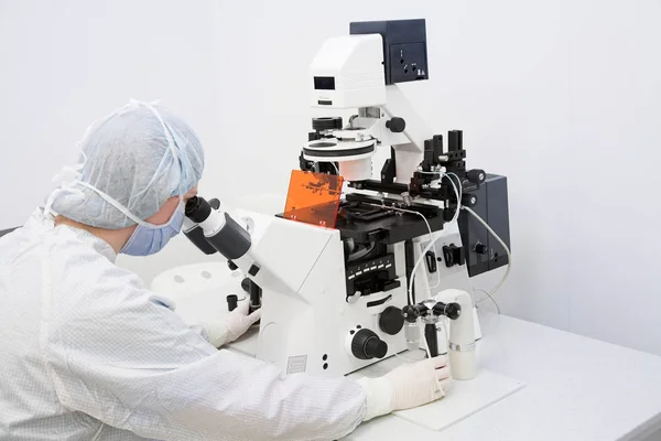 Γυναίκα ερευνητής ψάχνει στο μικροσκόπιο — Φωτογραφία Αρχείου