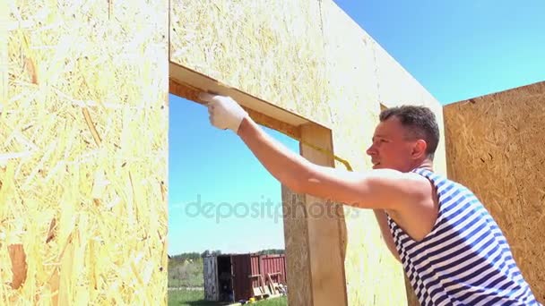 Bouwer bouw houten huis — Stockvideo