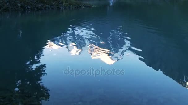 Surface de l'eau reflétant les montagnes enneigées — Video