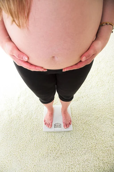 Donna incinta su bilance di peso — Foto Stock
