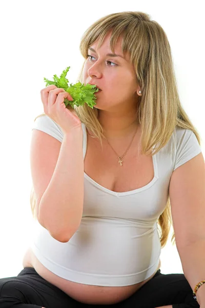 Mulher grávida comendo alface — Fotografia de Stock