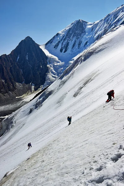 Alpinistas senderismo en montañas nevadas — Foto de Stock