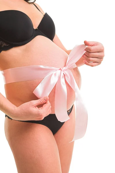 Pregnant woman with ribbon around belly — Stock Photo, Image