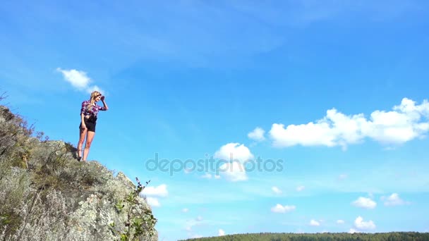 Mujer joven de pie en la colina — Vídeos de Stock