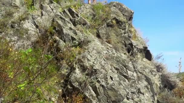 Young woman standing on mountain cliff — Stock Video