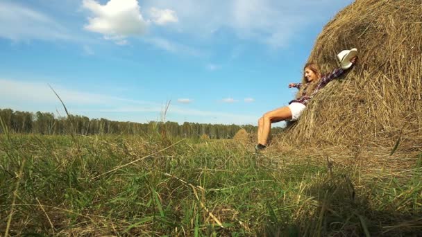 Young woman falling on hay stack — Stock Video