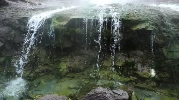 Kleiner Wasserfall, der von felsigen Klippen fließt — Stockvideo