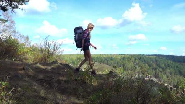 Жінка-туристка, що гуляє на зеленому пагорбі — стокове відео