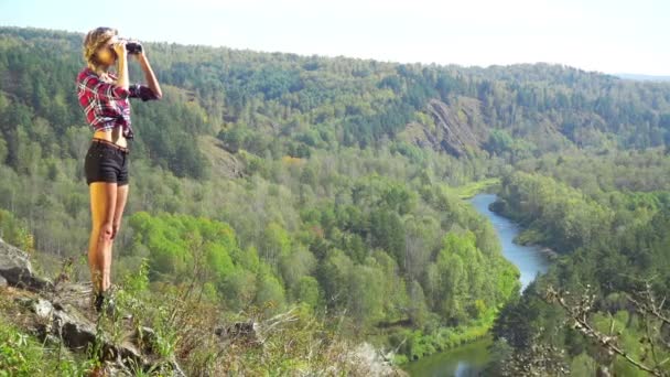 Jeune femme blonde touriste sur une falaise — Video