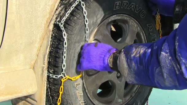 Man putting snow chains on tire — Stock Video