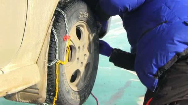 Smrtelný člověk sněhové řetězy na pneumatiku — Stock video
