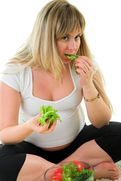 Беременная женщина ест овощи — стоковое фото