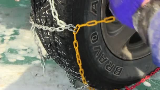 Man putting snow chains on tire — Stock Video