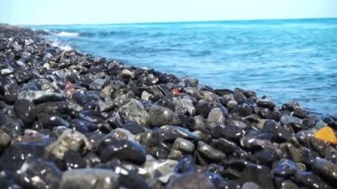 Dalgalar çakıl plajı üzerinde rulo