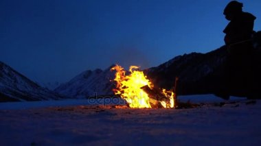 Monk kamp ateşi kış dağlarda, ağır çekim yakınındaki Isınma