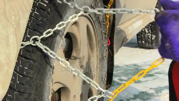 Man putting snow chains on tire — Stock Video