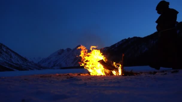 モンクは冬山 スローモーションでキャンプファイヤーの近く地球温暖化します — ストック動画