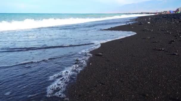 Морські хвилі на чорному пляжі — стокове відео