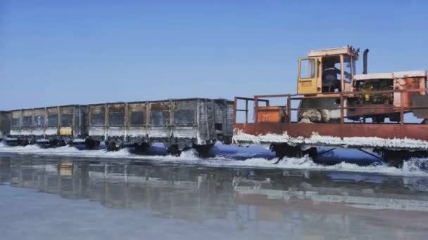 塩湖を通って水の中に敷設された鉄道に古い列車に乗る 列車は水から移動します ブルリン湖で塩を採掘 アルタイ ブルソル ロシアだ 2019年8月 — ストック動画
