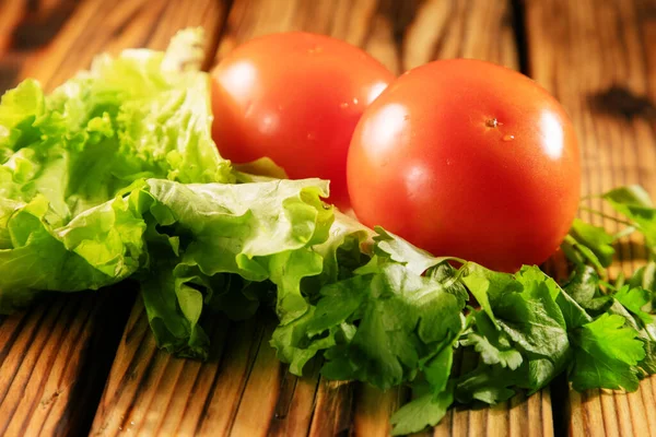 Zwei Tomaten Und Grünzeug Auf Dem Holztisch — Stockfoto