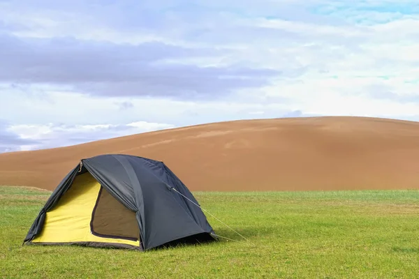Een Tent Een Groen Grasveld Aan Rand Van Een Zandwoestijn — Stockfoto