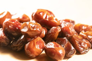 Açık ahşap masada kuru kahverengi hurma meyvesi.