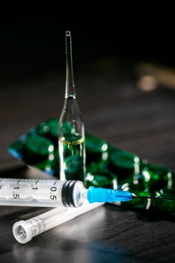 Haplar, şırınga ve Aşıyla Kara Masa