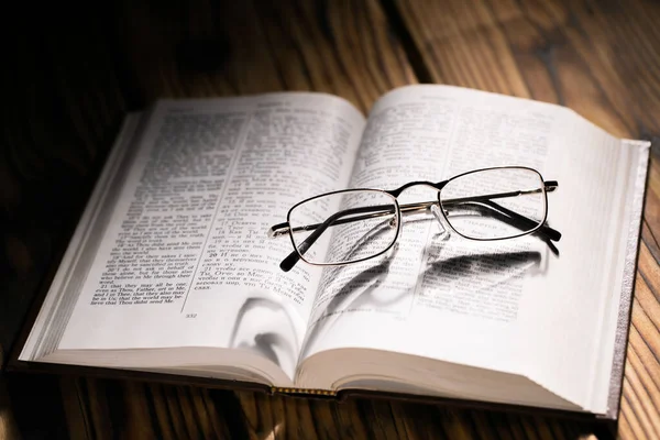 Světlo Vrhalo Stíny Brýlí Otevřenou Knihu Mělkou Hloubkou Pole Bible — Stock fotografie