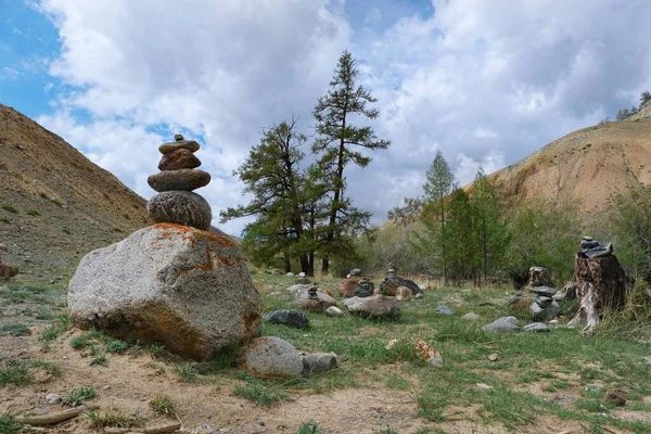 中央アジアの山の谷で カラマツの木やケアンと呼ばれる石の山 — ストック写真