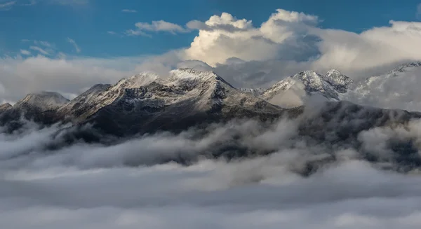 Schneebedeckte Gipfel in Wolken. Morgengrauen. Mount Mamkhurts. — Stockfoto