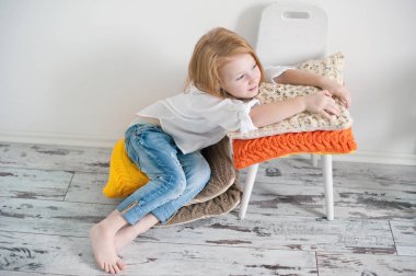 Yastıklar üzerinde oturan kız